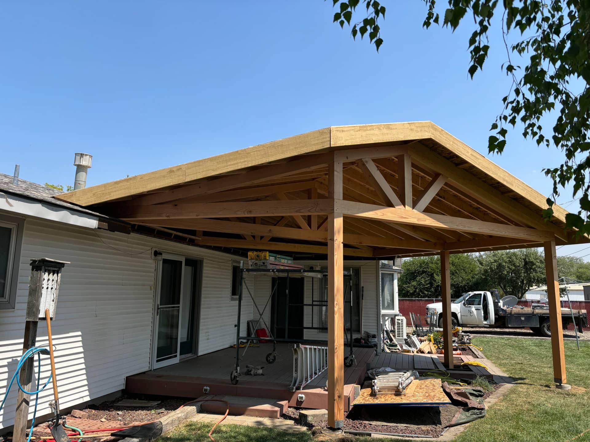 unfinished exterior awning on light gray house over front porch
